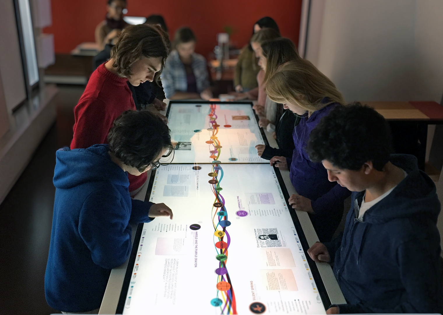 Visitors using a large-format touchscreen table interactive.